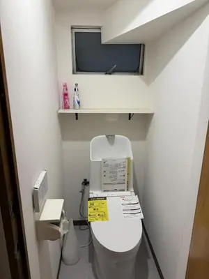 a small bathroom with a toilet with a window at Joyful inn in Tokyo