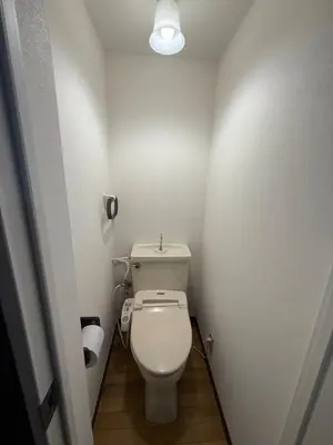 a small bathroom with a white toilet and a light at Joyful inn in Tokyo