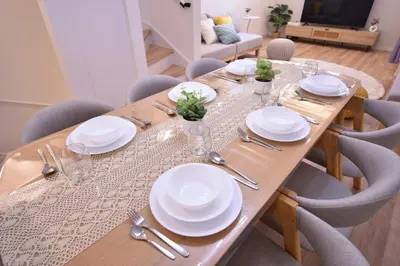 a wooden table with white plates and silverware on it at 100sqm 4BDR New House! 6 minutes from Skytree by train in Tokyo