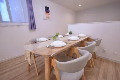 a dining room with a long wooden table and chairs at 100sqm 4BDR New House! 6 minutes from Skytree by train in Tokyo