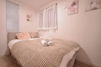 a bedroom with a bed with two stuffed animals on it at 100sqm 4BDR New House! 6 minutes from Skytree by train in Tokyo