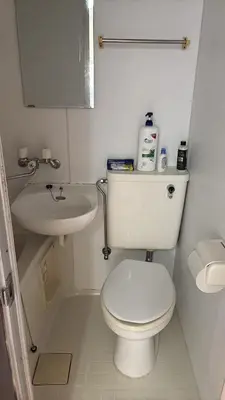 a white bathroom with a toilet and a sink at \u7b2c\u4e00\u30a2\u30d1\u30fc\u30c8 in Tokyo