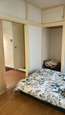 a bedroom with a bed in a room with a mirror at \u7b2c\u4e00\u30a2\u30d1\u30fc\u30c8 in Tokyo
