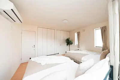 two beds in a bedroom with white walls at The Sky View Oshiage,Tokyo in Tokyo