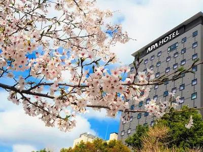 a tree with pink flowers in front of a building at APA Hotel Keisei Ueno Ekimae in Tokyo