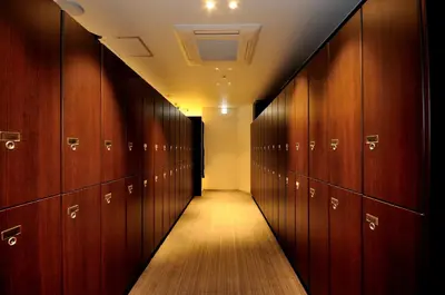 a hallway with wooden lockers in a locker room at Spa&Capsule Hotel Grandpark Inn Kitasenju in Tokyo