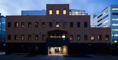 a brown building with lights on in a city at Tokyo Ariake Bay Hotel in Tokyo