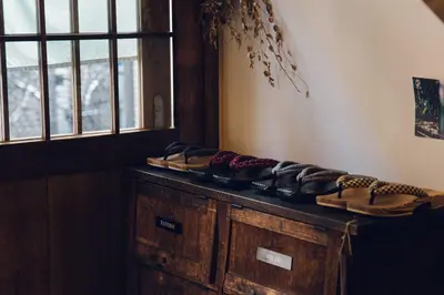 a pile of shoes sitting on top of a wooden cabinet at hanare in Tokyo