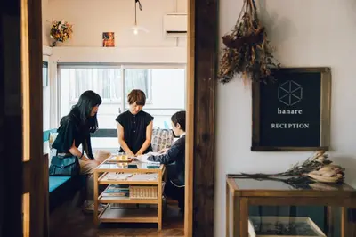 a group of people standing around a table in a room at hanare in Tokyo