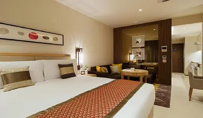 a hotel room with a bed and a living room at Oakwood Premier Tokyo in Tokyo