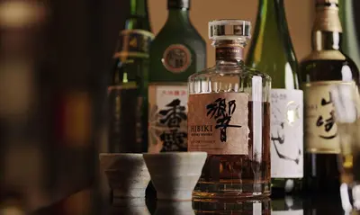 a bottle of alcohol on a table with bottles of wine at Oakwood Premier Tokyo in Tokyo