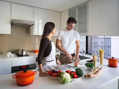 a man and woman standing in a kitchen preparing food at Oakwood Premier Tokyo in Tokyo