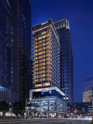 a tall building in a city at night at Oakwood Premier Tokyo in Tokyo