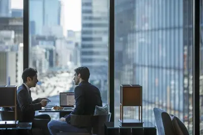 two men in an office with a view of a city at Oakwood Premier Tokyo in Tokyo