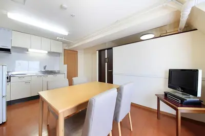 a kitchen and dining room with a wooden table and chairs at Shinjuku Urban Hotel in Tokyo