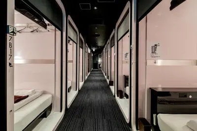 a corridor of a train with beds in it at First Cabin Akasaka in Tokyo