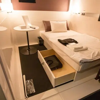 a small room with a bed and a small table at First Cabin Akasaka in Tokyo