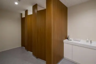 a bathroom with a sink and a wooden wall at First Cabin Akasaka in Tokyo