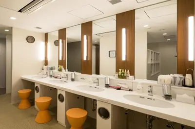 a bathroom with three sinks and a large mirror at First Cabin Akasaka in Tokyo