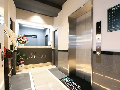 a lobby with a love tax sign on the wall at HOTEL LiVEMAX Asakusa Sky Front in Tokyo