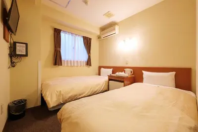a hotel room with two beds and a window at Hotel Suntargas Ueno in Tokyo