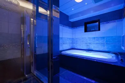 a blue bathroom with a tub and a tv at HOTEL & SPA J-MEX Shinjuku Kabukicho (Adult Only) in Tokyo