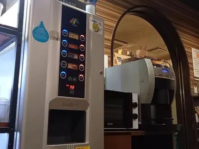 a vending machine with a microwave and a coffee maker at Capsule Land Yushima (Male Only) in Tokyo