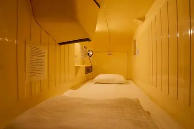 a small hallway with a bed in a room at Capsule Land Yushima (Male Only) in Tokyo