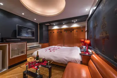 a bedroom with a bed and a couch and a tv at Hotel Moana Shinjuku (Adult Only) in Tokyo