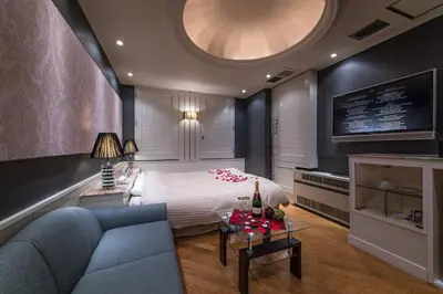 a bedroom with a bed and a couch and a tv at Hotel Moana Shinjuku (Adult Only) in Tokyo
