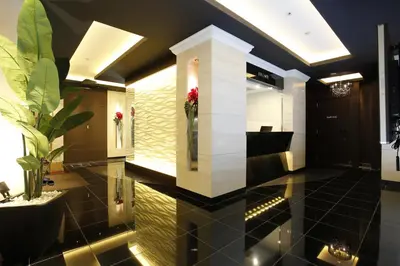 a lobby with a black tiled floor with flowers in vases at Hotel Moana Shinjuku (Adult Only) in Tokyo