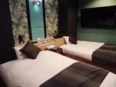 a hotel room with two beds and a flat screen tv at Hotel Moana Otsuka (Adult Only) in Tokyo
