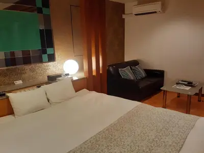 a bedroom with a bed and a couch and a chair at Hotel Moana Otsuka (Adult Only) in Tokyo
