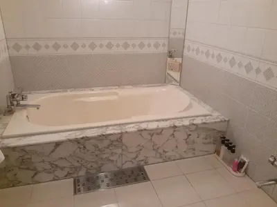 a white bath tub in a bathroom with a tile floor at Hotel Moana Otsuka (Adult Only) in Tokyo