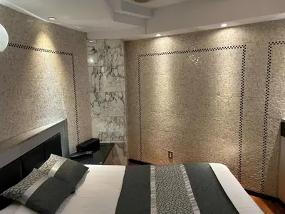 a bedroom with a bed and a wall with gold tiles at HOTEL PAL Otsuka -Adult Only- in Tokyo