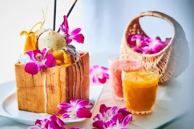 a table with a plate of food and a basket of flowers at Hotel Balian Resort Kinshicho in Tokyo