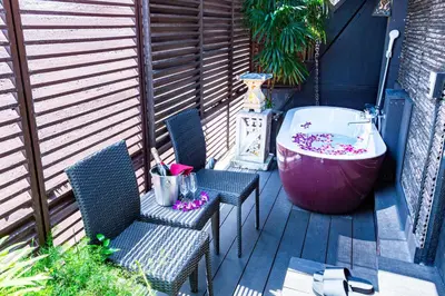a deck with two chairs and a bath tub at Hotel Balian Resort Kinshicho in Tokyo