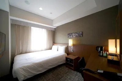 a hotel room with a bed and a window at ibis Styles Tokyo Ginza in Tokyo