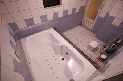 a bathroom with a tub and a toilet at HOTEL ATLAS Shinkabukicho (Adult Only) in Tokyo