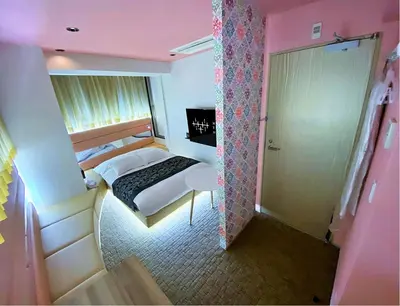 a small room with a bed and a door to a bedroom at HOTEL THE HOTEL SHINJUKU (Adult Only) in Tokyo