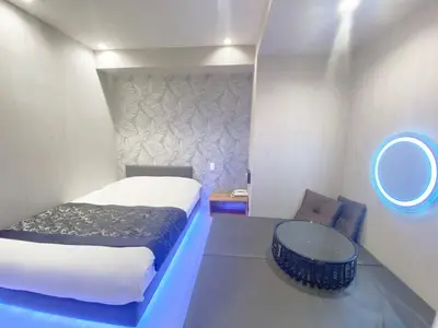 a bedroom with a bed and a table and a mirror at HOTEL THE HOTEL SHINJUKU (Adult Only) in Tokyo