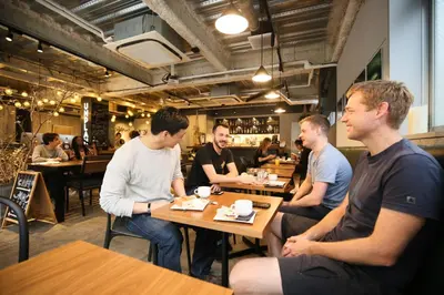 a group of men sitting at tables in a restaurant at UNPLAN Kagurazaka in Tokyo