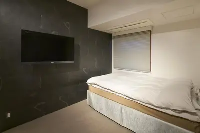 a bedroom with a bed and a flat screen tv at Shinjuku City Hotel N.U.T.S Tokyo in Tokyo