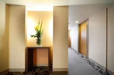 a hallway with a vase of flowers on a table at Vessel Inn Ueno Iriya Station in Tokyo