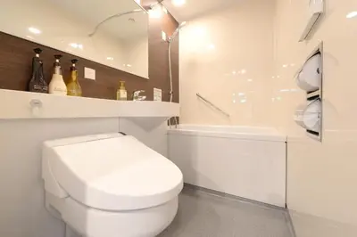 a white bathroom with a toilet and a tub at Vessel Inn Ueno Iriya Station in Tokyo