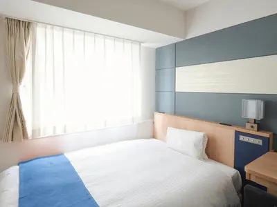 a bedroom with a white bed and a window at Vessel Inn Ueno Iriya Station in Tokyo