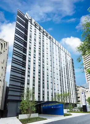 a large white building with a sign on it at Hotel Mystays Premier Akasaka in Tokyo