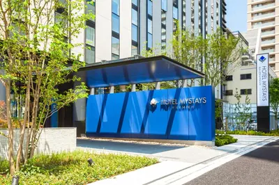a blue building with a sign in a city at Hotel Mystays Premier Akasaka in Tokyo
