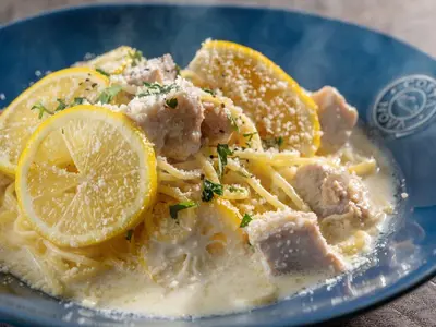 a blue plate of pasta with meat and lemon slices at Hotel Mystays Premier Akasaka in Tokyo