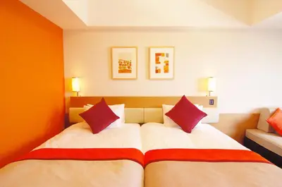 a bedroom with two beds with red pillows at MAIHAMA VIEW HOTEL by HULIC Formerly Tokyo Bay Maihama Hotel in Urayasu